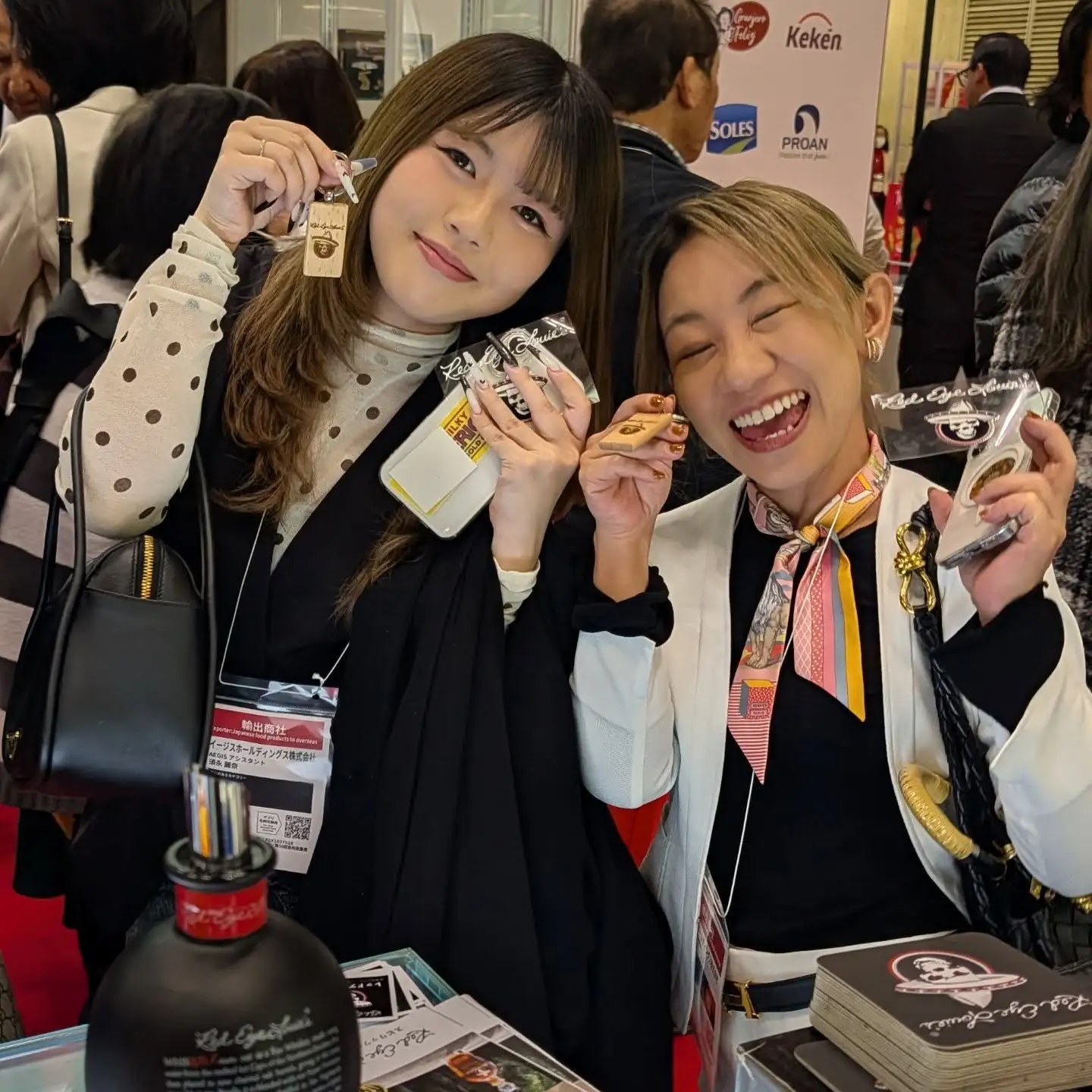 Brand Engagement: Visitors at FoodEx Japan 2026 holding Red Eye Louie’s branded merchandise and keychains.