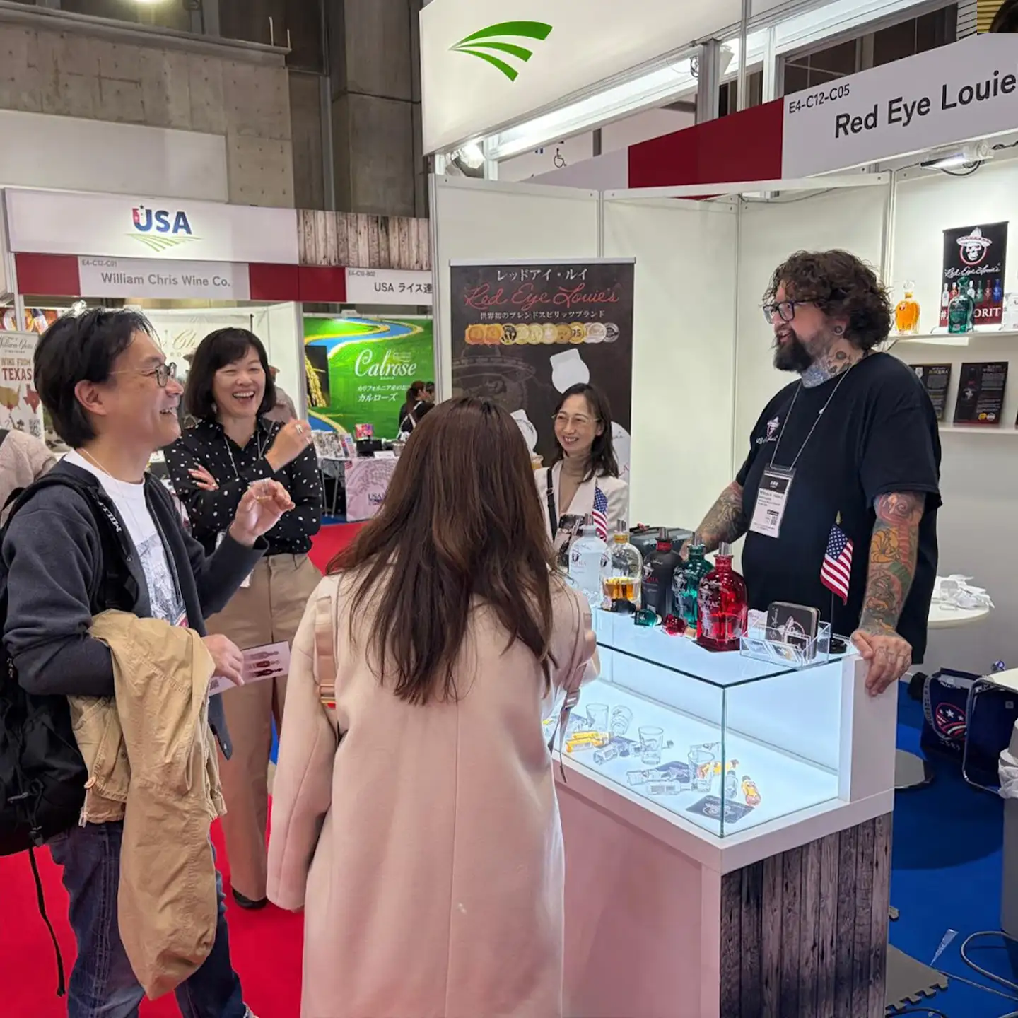 Consumer Interaction An attendee at the Red Eye Louie’s exhibition booth holding a bottle of RumQuila.