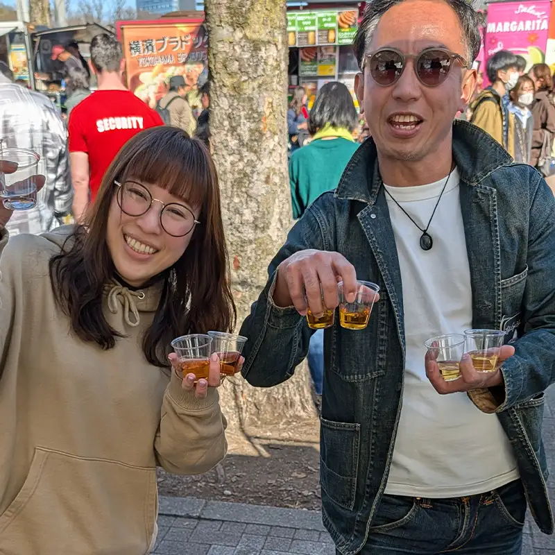 Brand Engagement: Visitors at FoodEx Japan 2026 holding Red Eye Louie’s branded merchandise and keychains.
