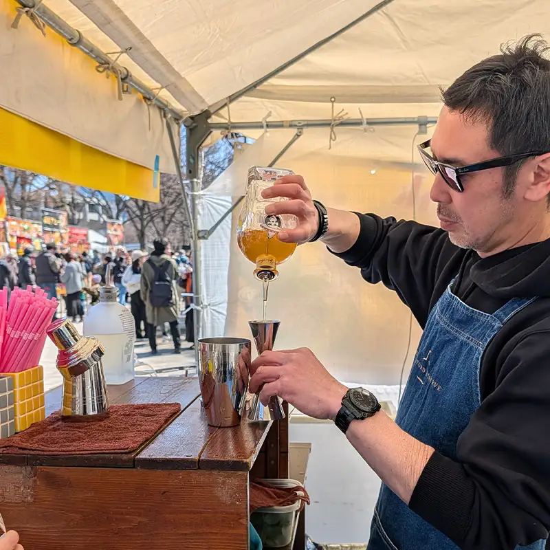Consumer Interaction An attendee at the Red Eye Louie’s exhibition booth holding a bottle of RumQuila.